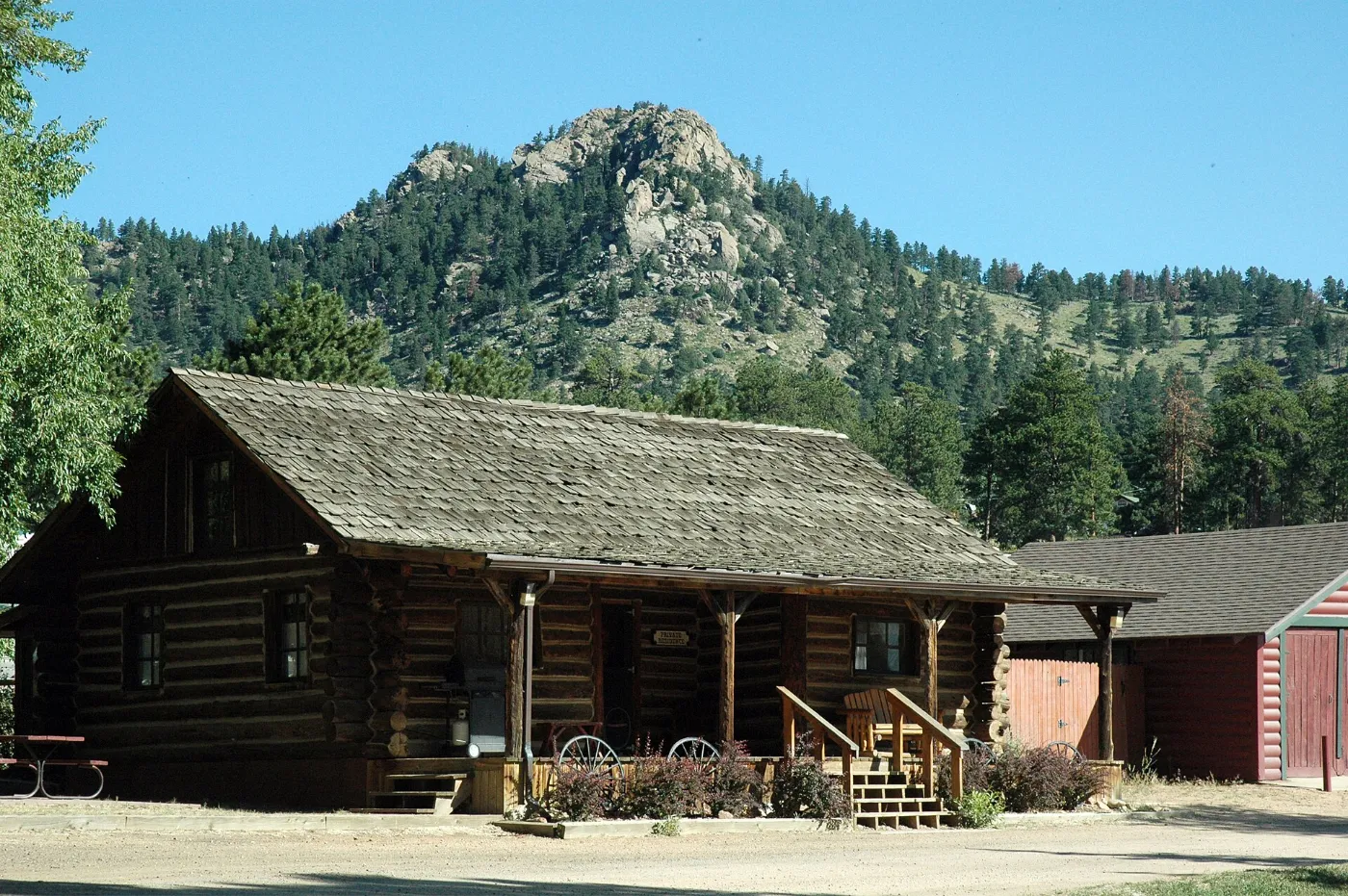 A rustic log cabin below a rocky mountain peak near Estes Park